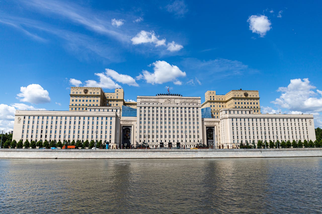 A majestic riverfront building captured on a sunny day with clear blue skies.