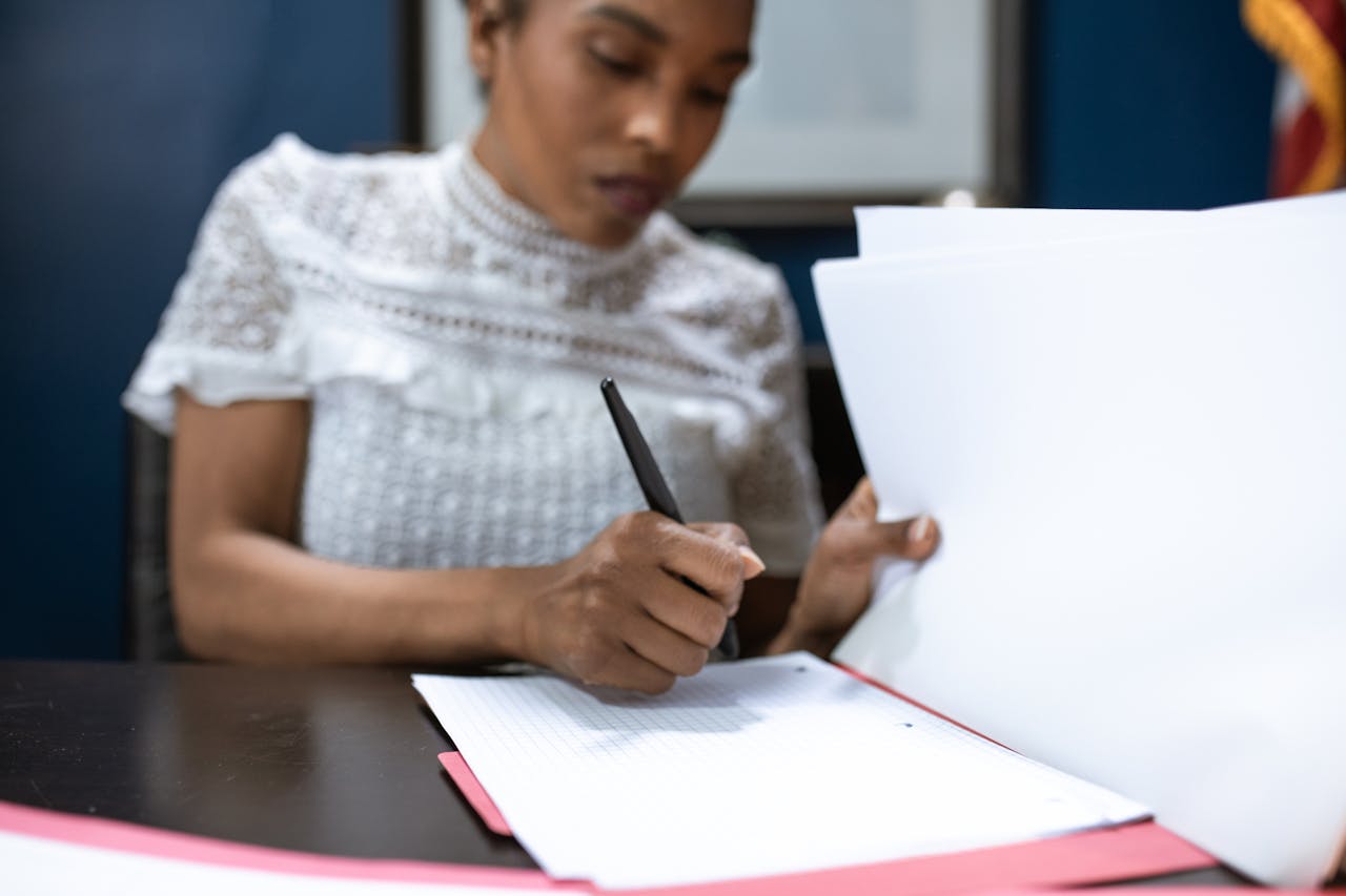 services-04 African American woman signing documents in an elegant office setting, showcasing leadership.